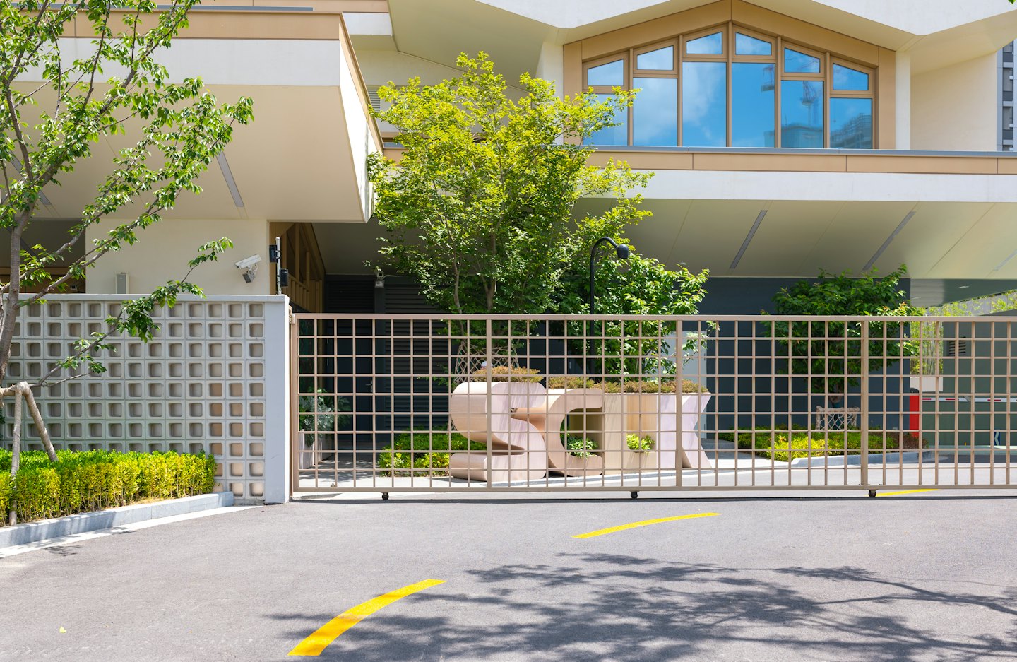 Modern building entrance with planter box security gate and trees.