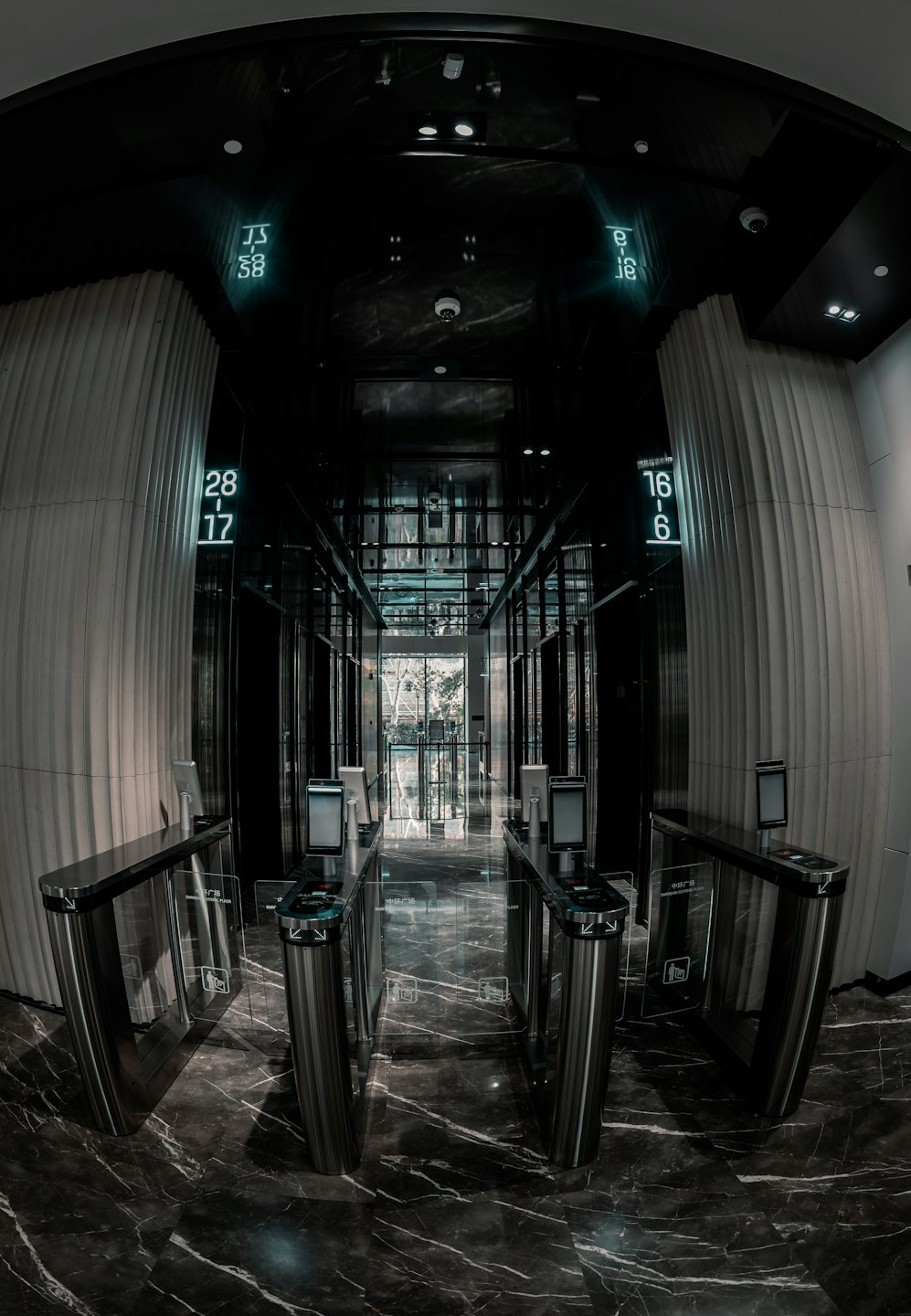 Stainless steel turnstiles in a sleek corporate building entrance.