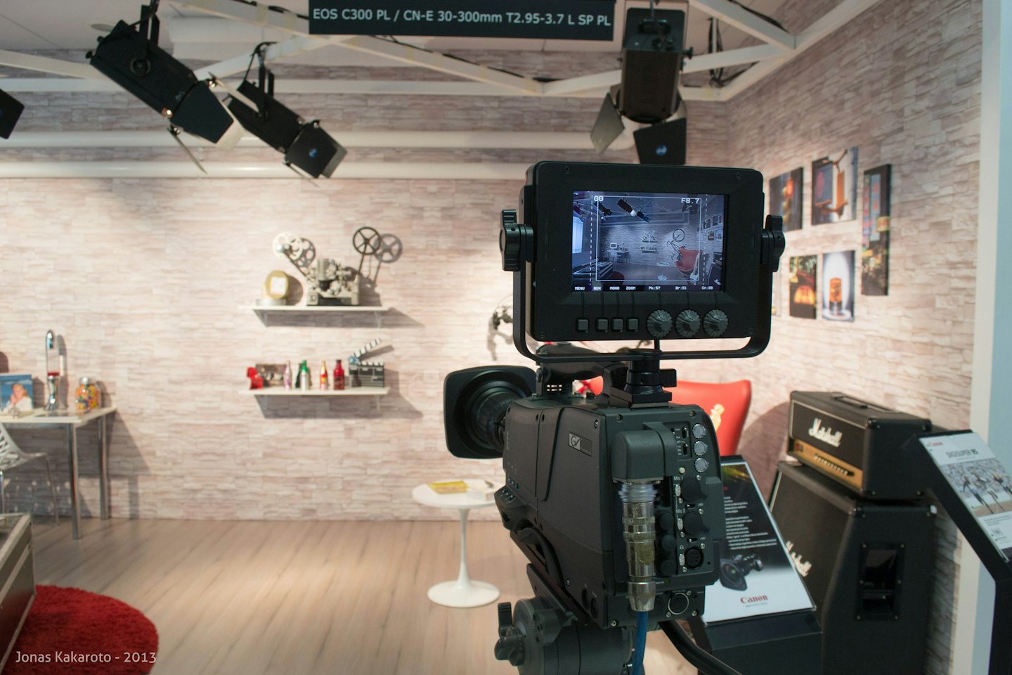 Professional video camera and monitor in a studio with movie memorabilia.