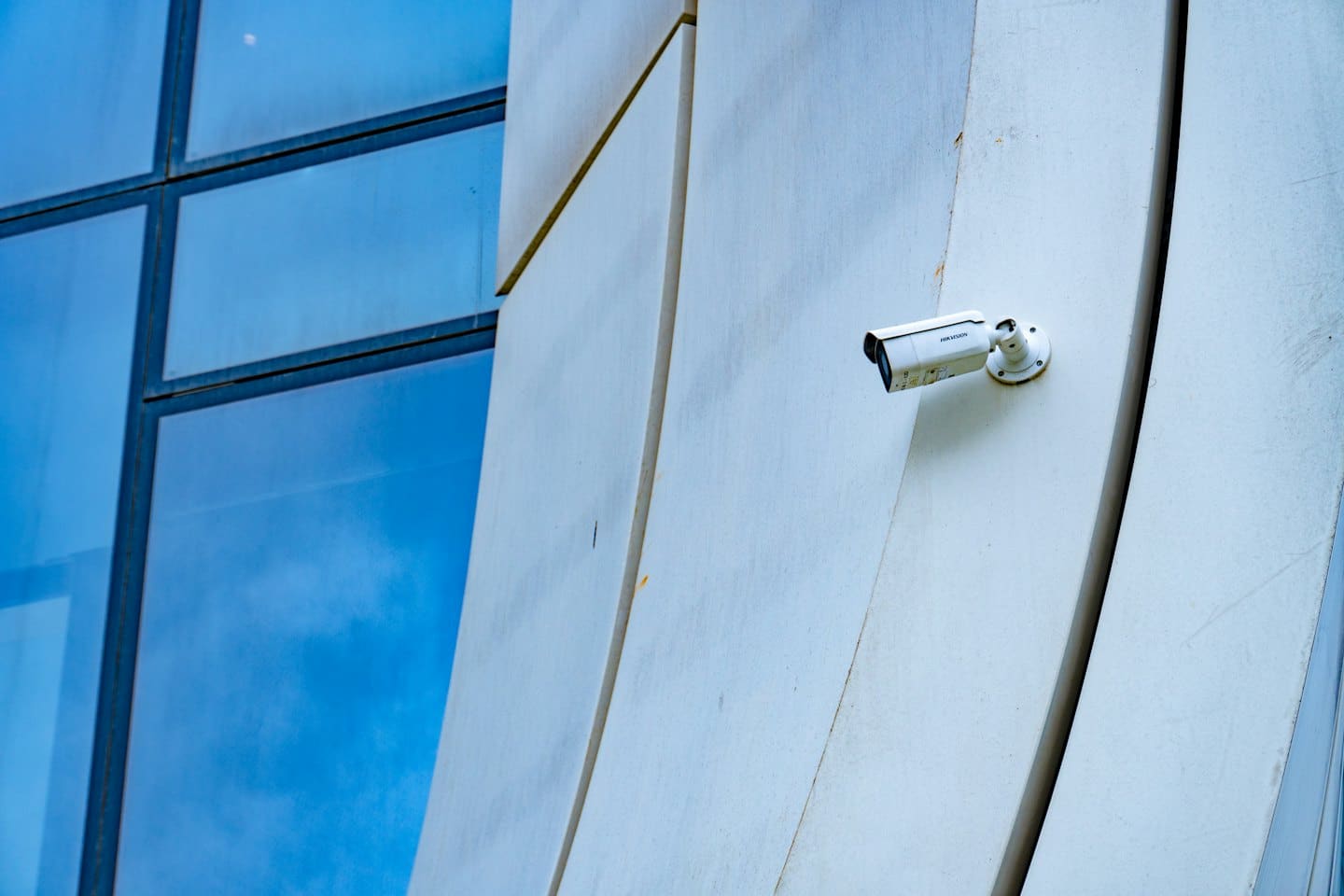 Security camera mounted on a modern building facade.